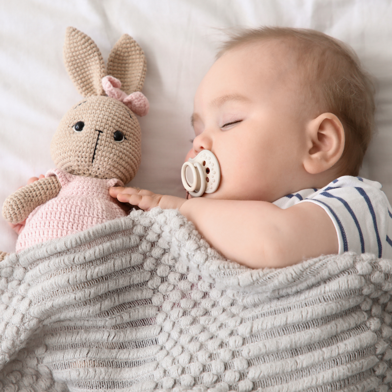 Slapende baby met knuffel en zachte deken voor een geborgen gevoel
