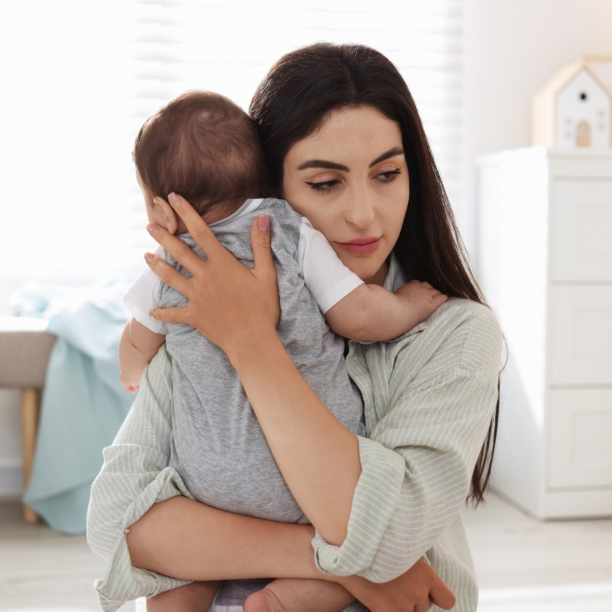 Woman holding a baby in a home setting