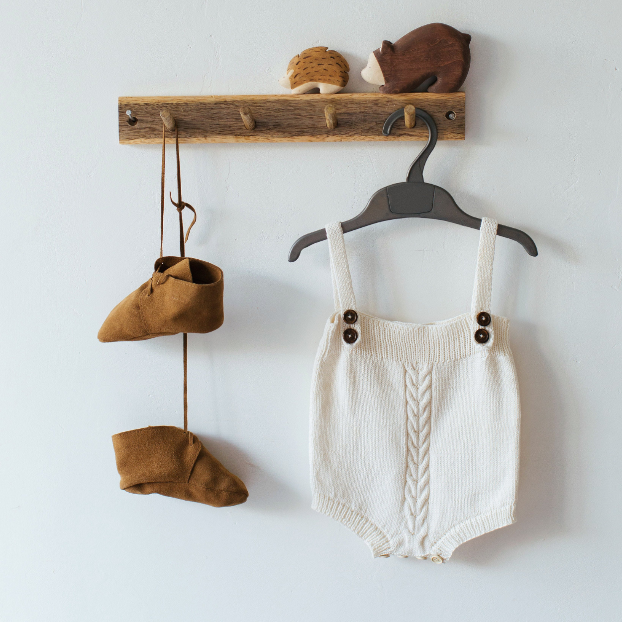 Neutrale baby outfit met gebreide romper, mutsje en accessoires