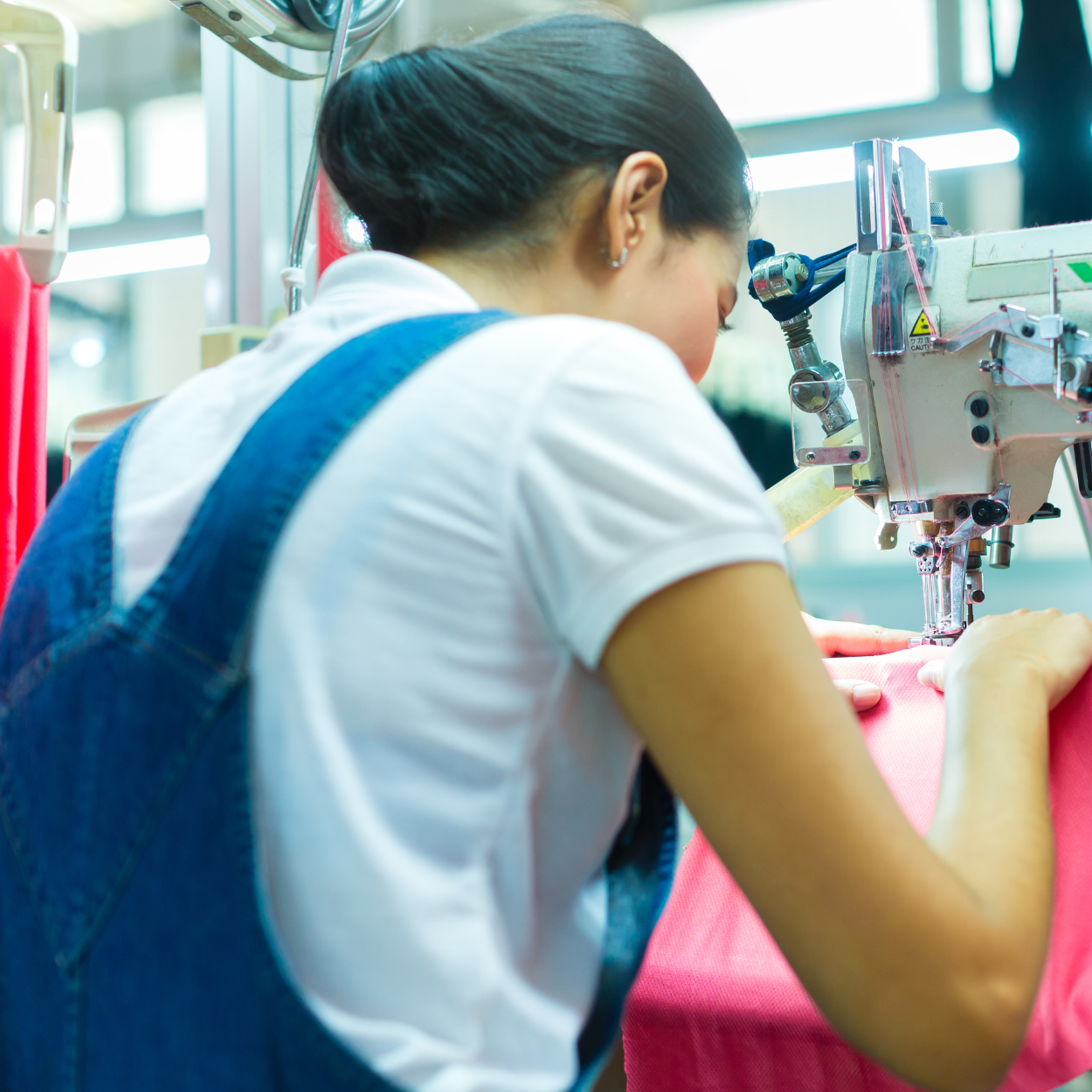 Person working on a sewing machine in an industrial setting